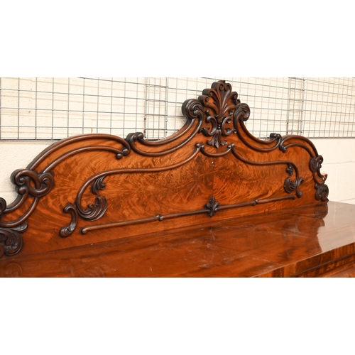 150 - A Victorian mahogany sideboard with scrolling raised back above three pulvinated frieze drawers on i... 