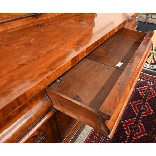 150 - A Victorian mahogany sideboard with scrolling raised back above three pulvinated frieze drawers on i... 