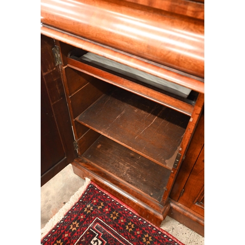 150 - A Victorian mahogany sideboard with scrolling raised back above three pulvinated frieze drawers on i... 