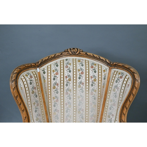 106 - A French wingback armchair, 20th century, floral brocade-style striped fabric