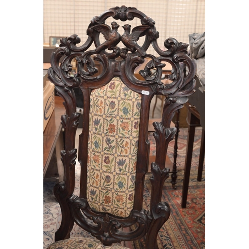 117 - A Continental oak high backed hall chair profusely carved foliate frame, the crest carved with two b... 