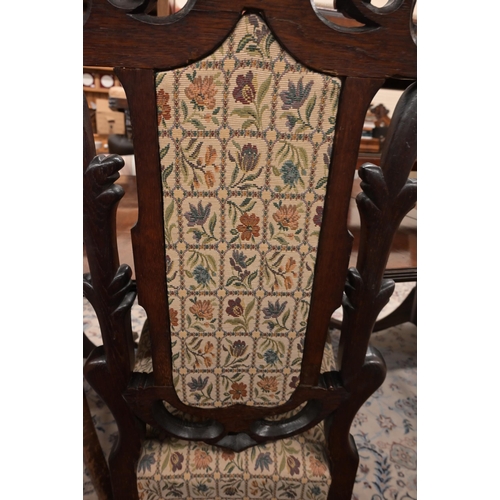 117 - A Continental oak high backed hall chair profusely carved foliate frame, the crest carved with two b... 