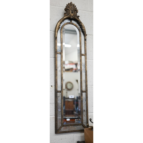 120 - A narrow bevelled wall mirror with antiqued glass borders and metal frame with anethmion crest, 28 x... 