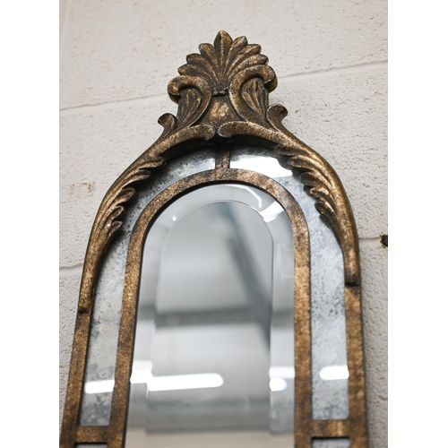 120 - A narrow bevelled wall mirror with antiqued glass borders and metal frame with anethmion crest, 28 x... 