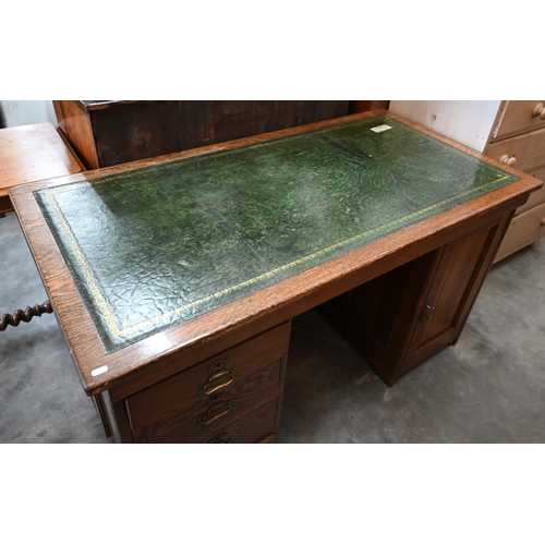 13 - An oak kneehole desk with gilt-tooled green leather top over four drawers (left) and panelled cupboa... 