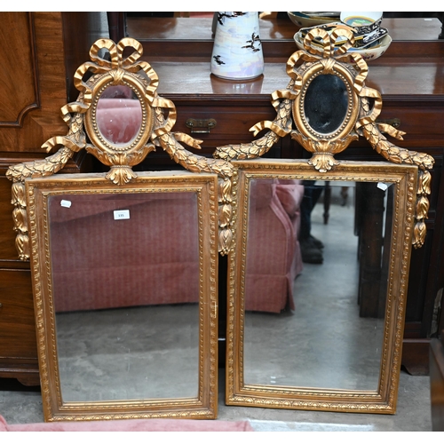 135 - A pair of neo-classical style wall mirrors with small oval and bevelled plates, gilt frames with rib... 