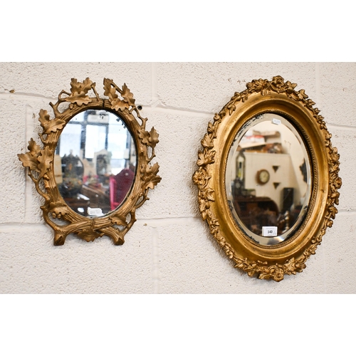 140 - A bevelled oval wall mirror in floral gilt frame, 42 x 48 cm to/w smaller oval mirror in oak leaf gi... 