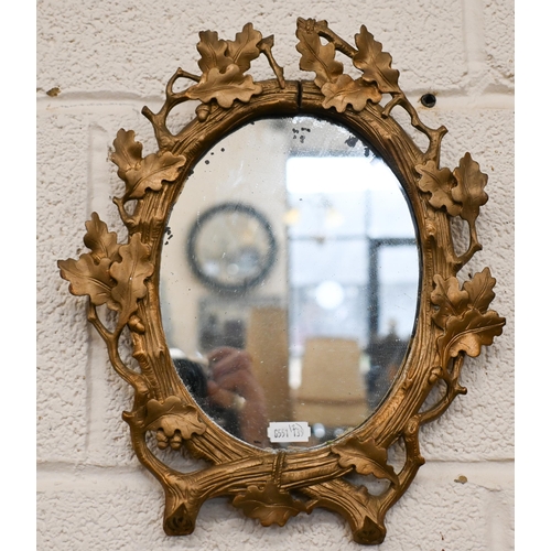 140 - A bevelled oval wall mirror in floral gilt frame, 42 x 48 cm to/w smaller oval mirror in oak leaf gi... 