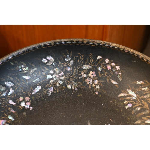 154 - A black papier-maché bowl with mother of pearl inlay on black painted tripod stand, 78 cm high