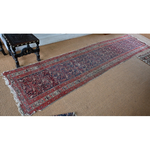 168 - An antique N W Persian runner of boteh design on navy ground, red and beige borders, worn, 406 x 90 ... 