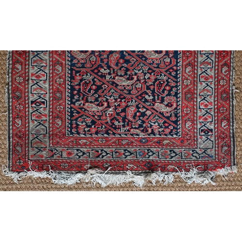 168 - An antique N W Persian runner of boteh design on navy ground, red and beige borders, worn, 406 x 90 ... 