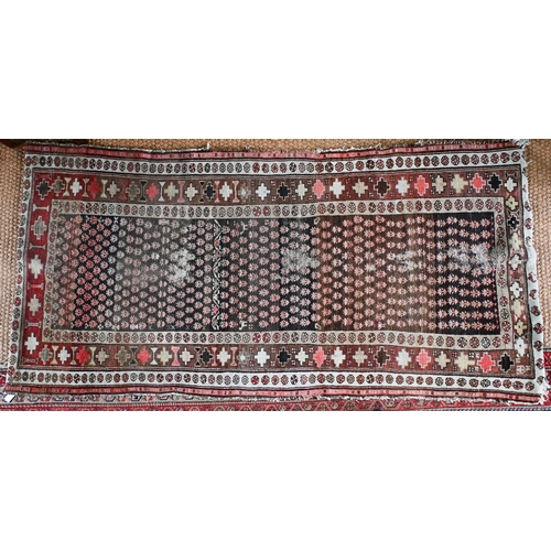 188 - A Kurdish repeat design rug, brown ground with geometric and floral borders, 216 cm x 105 cm