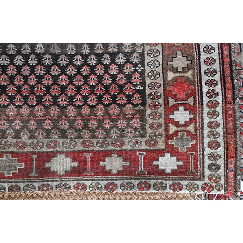 188 - A Kurdish repeat design rug, brown ground with geometric and floral borders, 216 cm x 105 cm