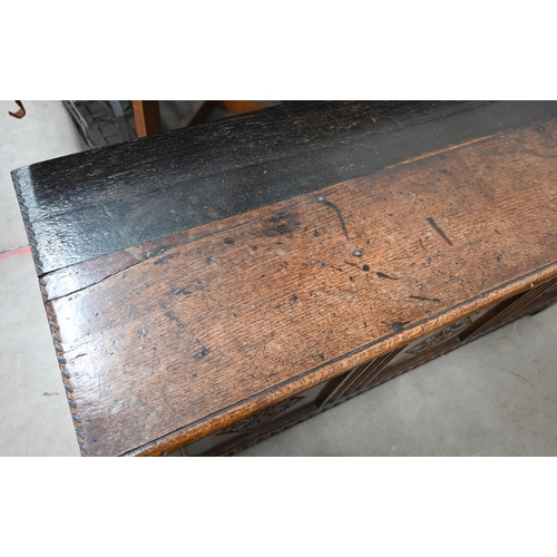 21 - An antique oak coffer, panelled construction with carved front 130 x 50 x 56 cm high