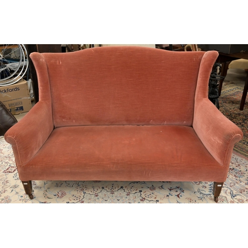 45 - An Edwardian mahogany framed camel back two seater settee, pink dralon upholstery, square supports a... 