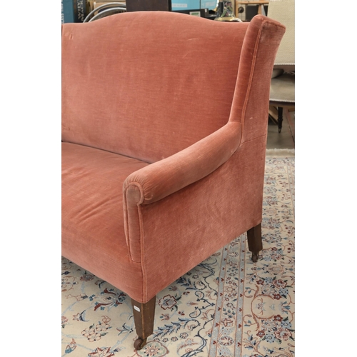 45 - An Edwardian mahogany framed camel back two seater settee, pink dralon upholstery, square supports a... 