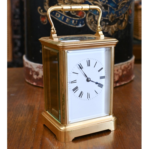 458 - A gilt brass carriage timepiece with top swing handle and bevelled glass panels, 18 cm high overall