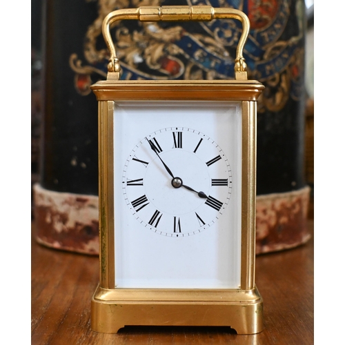 458 - A gilt brass carriage timepiece with top swing handle and bevelled glass panels, 18 cm high overall