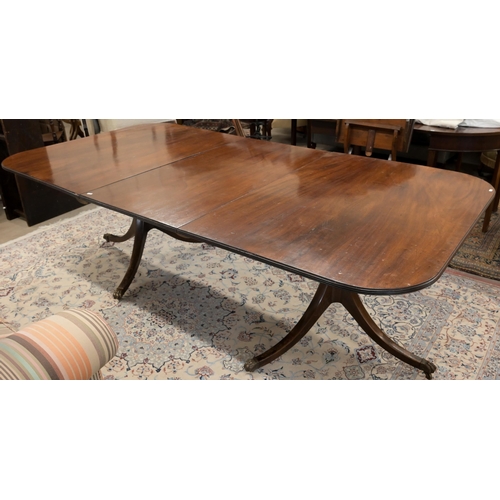 46 - A Regency style mahogany extending dining table with single central leaf on twin pedestal bases with... 