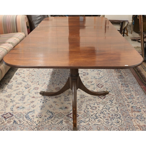 46 - A Regency style mahogany extending dining table with single central leaf on twin pedestal bases with... 