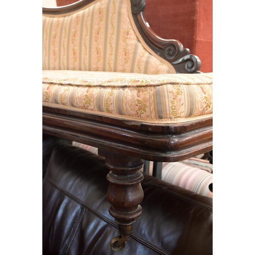 50 - A 19th century rosewood scroll-end chaise with shaped back, Regency floral striped fabric, on turned... 