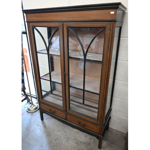 53 - An Edwardian walnut inlaid display cabinet with astragal glazed doors enclosing two shelves over two... 