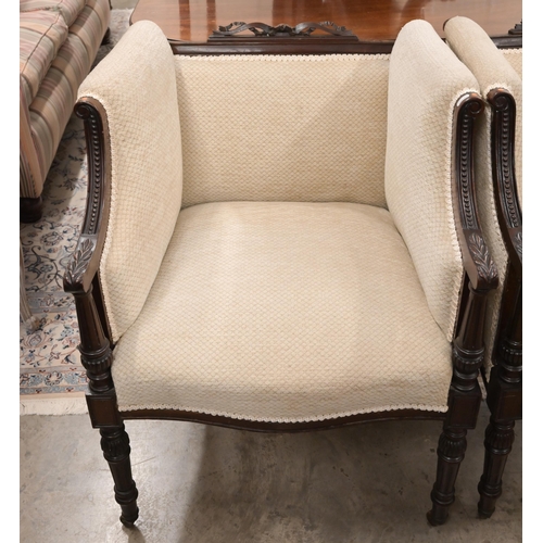 61 - A pair of carved mahogany ribbon crested salon armchairs in the Empire Style, with lattice stone fab... 