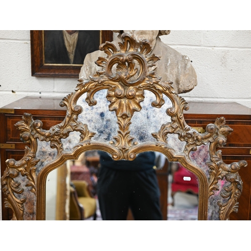 77 - A Chippendale style mirror with antiqued glass and decorative foliate gilt frame, a/f