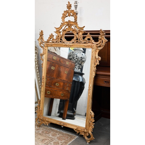 78 - An Italian reproduction mirror in decorative foliate carved gilt frame in 18th century manner, 100 c... 