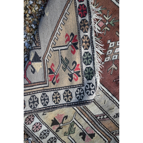 183 - An old golden ground washed Afghan rug, with three rows of stylised guls, 190 cm x 110 cm to/with an... 