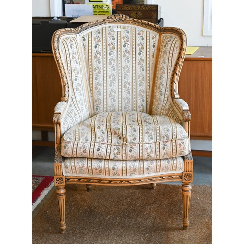 106 - A French wingback armchair, 20th century, floral brocade-style striped fabric