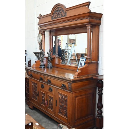 101 - A substantial Art Nouveau carved walnut mirror-backed sideboard with bevelled plate between turned p... 