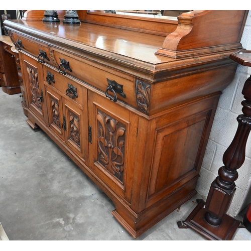 101 - A substantial Art Nouveau carved walnut mirror-backed sideboard with bevelled plate between turned p... 