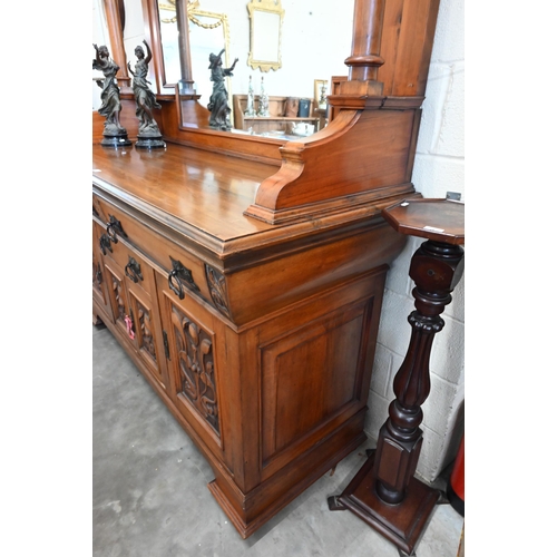 101 - A substantial Art Nouveau carved walnut mirror-backed sideboard with bevelled plate between turned p... 