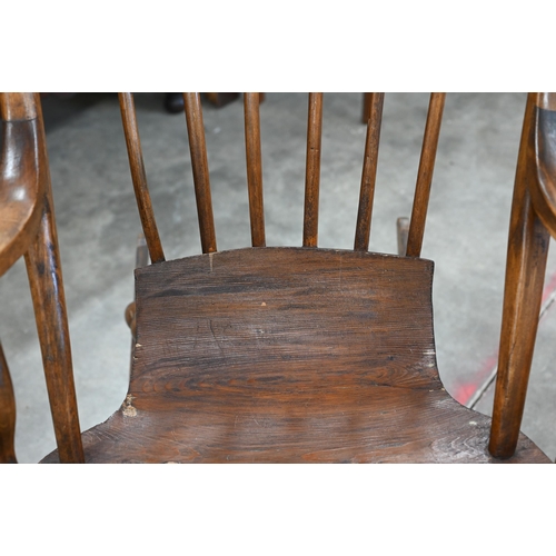 18 - A vintage Danish stained pine spindle back rocking chair with scroll seat and bobbin turned supports