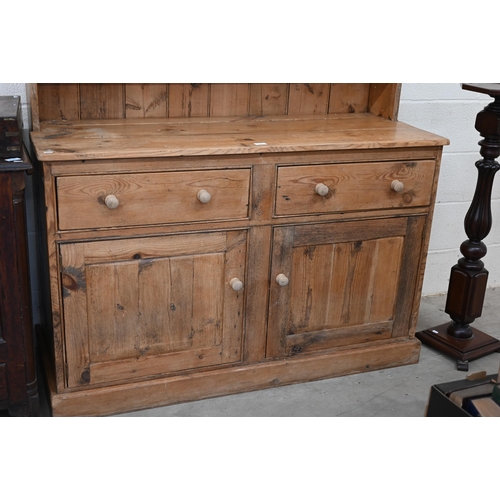 3 - A vintage pine low dresser with two drawers over panelled cupboards, 134 cm w x 52 cm d x 130 cm h