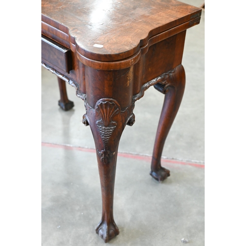 4 - A George II style figured walnut gate-leg card table, the shaped baize lined folding top over a sing... 