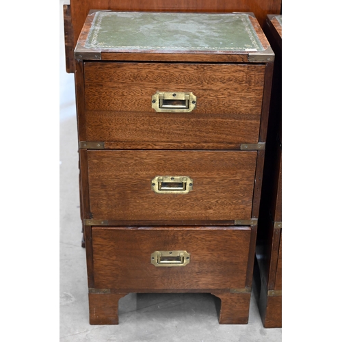 46 - A pair of campaign-style three drawer bedside chest with gilt tooled leather tops, brass mounts and ... 