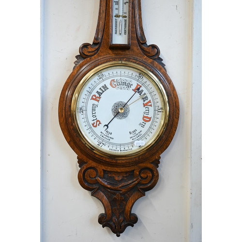 461 - # An antique carved oak banjo-cased aneroid barometer/thermometer 92cm high