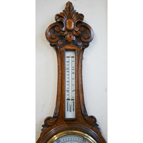 461 - # An antique carved oak banjo-cased aneroid barometer/thermometer 92cm high