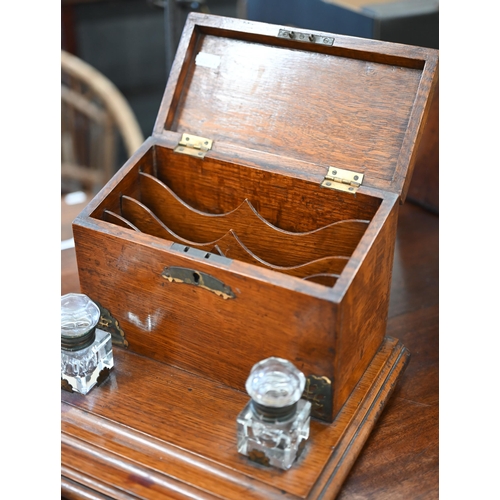 464 - An antique oak stationery box/inkstand with brass mounts, 28 cm wide