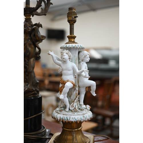 467 - An Italian white-glazed and gilded ceramic lamp modelled with three dancing putti, on brass base, 48... 