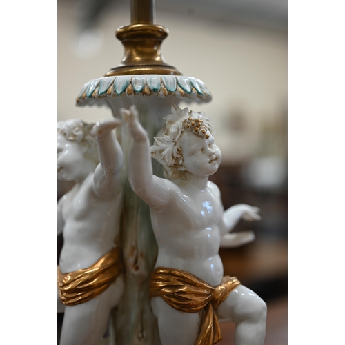 467 - An Italian white-glazed and gilded ceramic lamp modelled with three dancing putti, on brass base, 48... 