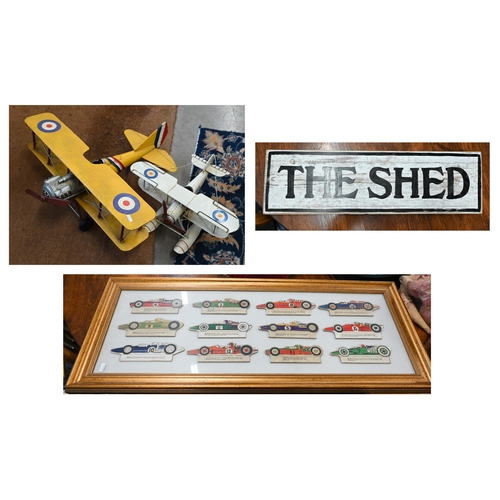 496 - Two modern tinplate bi-planes, a framed set of 1960s printed card Formula 1 racing cars and a 'The S... 