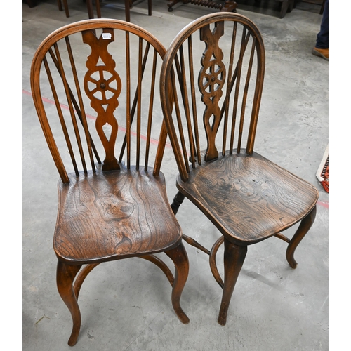 51 - A set of four provincial elm seated wheel back dining chairs with turned legs and crinoline front st... 