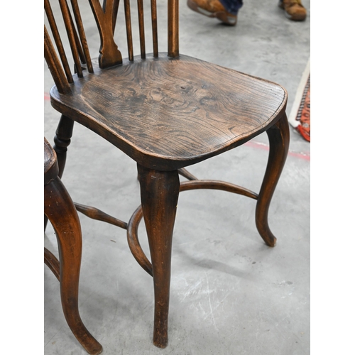 51 - A set of four provincial elm seated wheel back dining chairs with turned legs and crinoline front st... 