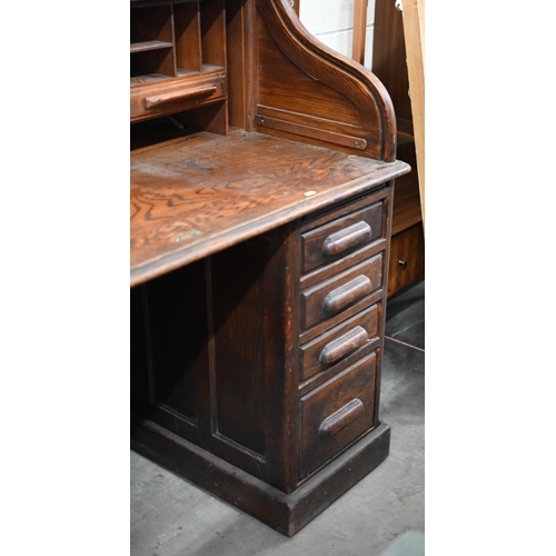 54 - An early 20th century oak tambour roll-top desk with eight drawers, 128 cm w x 78 cm d x 120 cm h