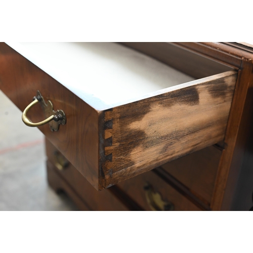 63 - A George III style walnut chest with four long drawers fitted with brass handles, raised on bracket ... 