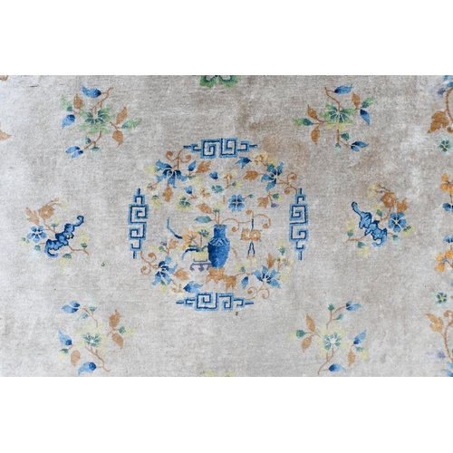 74 - A 1930's Chinese Peking wool carpet, scattered design with bats, auspicious emblems and floral spray... 