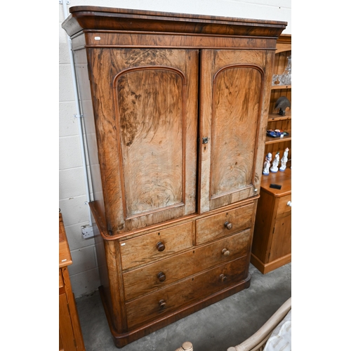 80 - A Victorian stained mahogany (imitation walnut) linen press with arch panelled doors enclosing four ... 